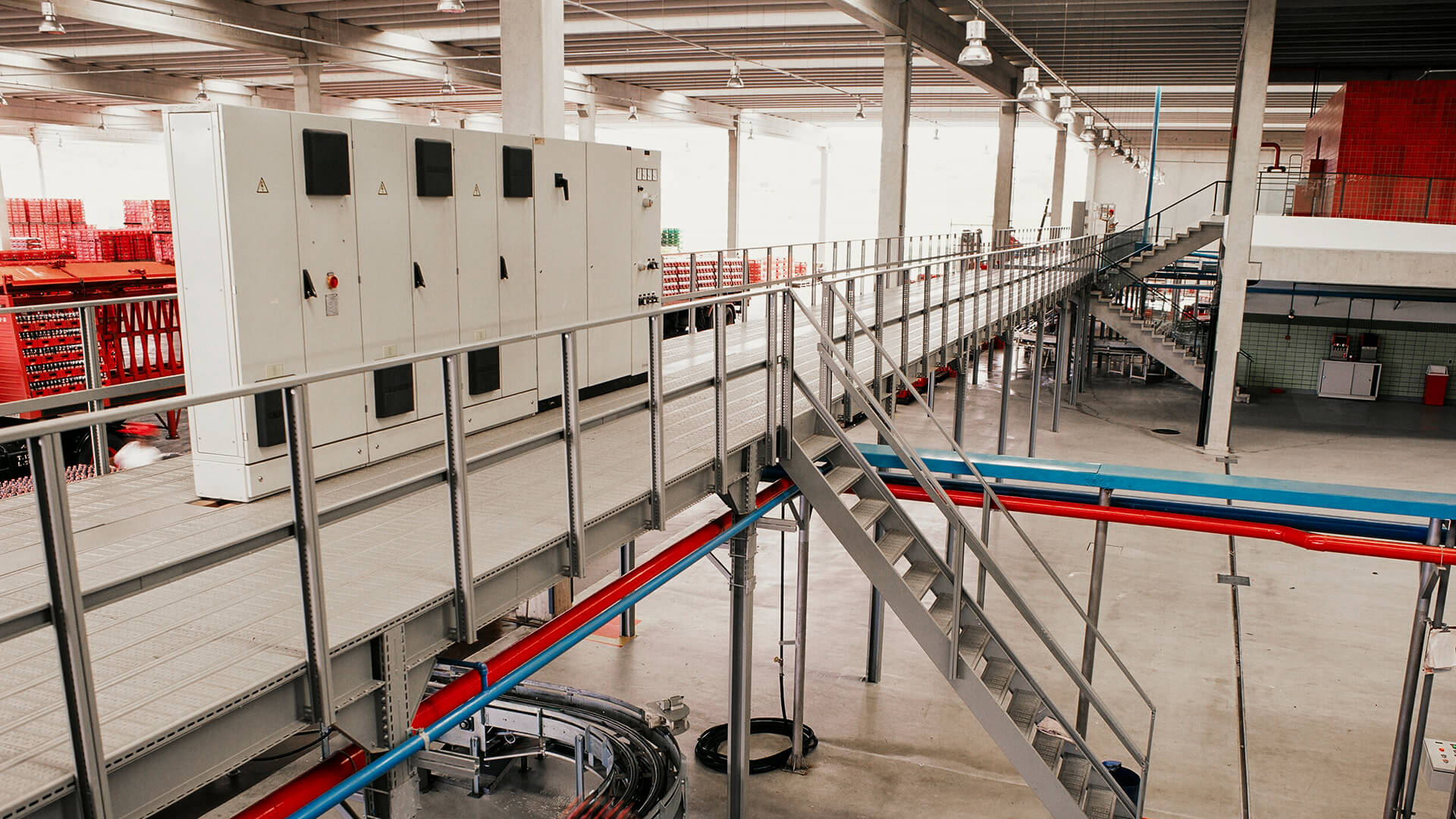 Imagem de destaque com estruturas metálicas de armazenagem verticalizadas em armazém industrial