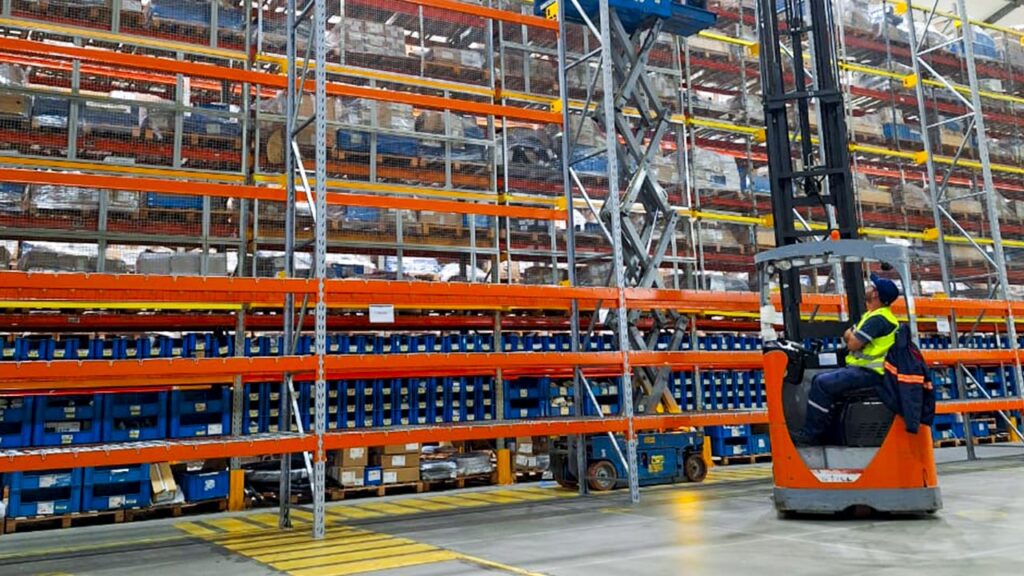Sistema de porta-paletes com empilhadeiras movimentando cargas paletizadas