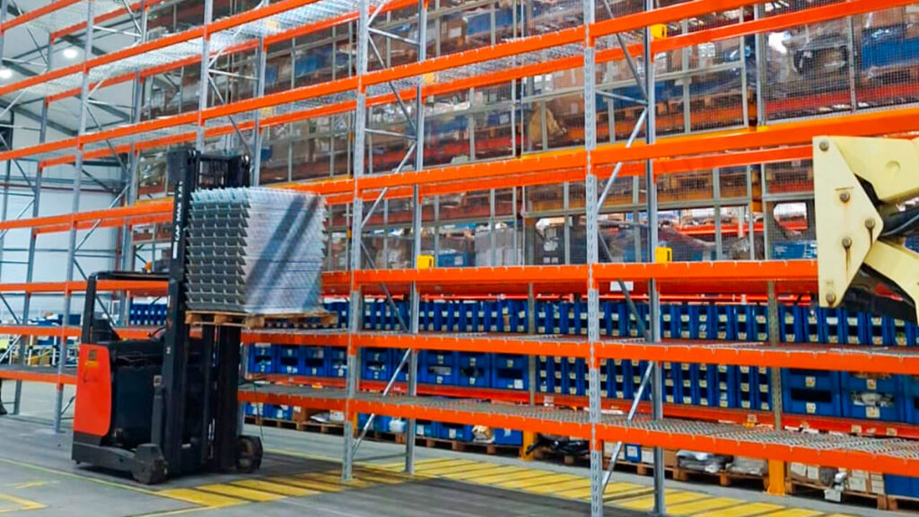 Expansão de porta-paletes modular com empilhadeira em galpão logístico