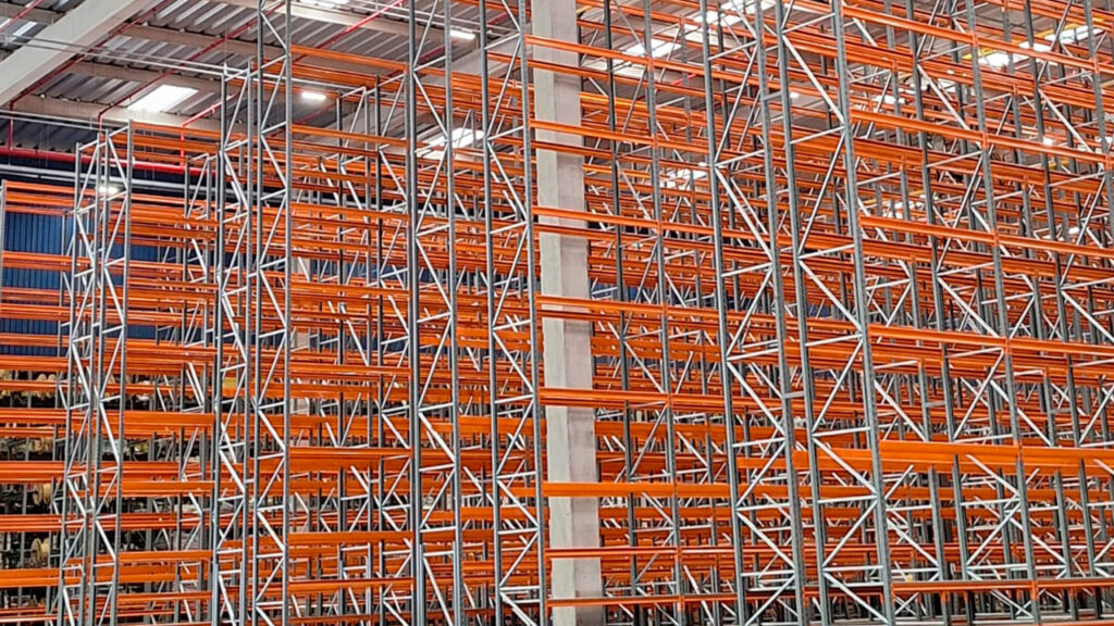 Vista interna de centro de distribuição com estruturas metálicas organizadas